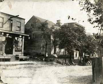 Children sitting on a porch at a house near a store on East Burke Street, Martinsburg, W. Va.