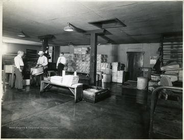 Three men packing watercress in a storing area, Martinsburg, W. Va.