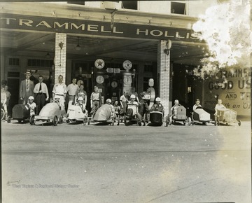 Boys are lined up in front of a gas station.