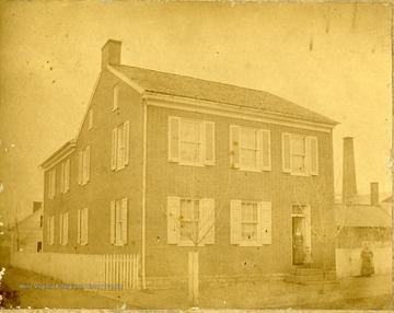 Three people stand in front of the house.