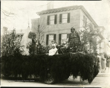 Children and adults dressed up as Native Americans ride on the float. 