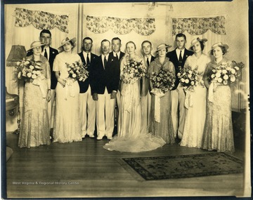 Men and women of a wedding party pose for a group portrait.