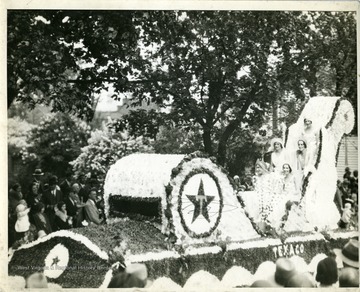 Several beautiful ladies are riding the Texaco Float in Martinsburg, West Virginia.