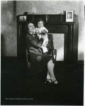 Woman sitting on a chair with a baby in her lap, Martinsburg, W. Va.