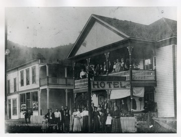 Townspeople are standing on the balcony and porch of the Rutherford Hotel on 21st Street, Nitro, West Virginia.