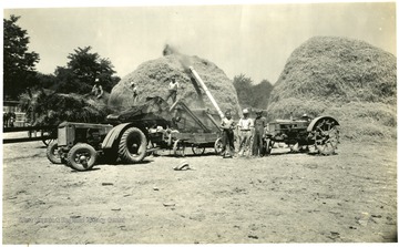 Seven men working on making large hay piles with machinery, Martinsburg, W. Va.