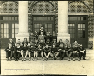 Group portrait of football team sitting on stairs with their coaches, Martinsburg, W. Va.