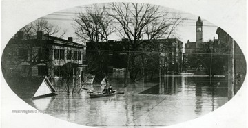 People in a canoe float down the street.