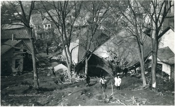 'Looking down toward Avery St., Parkersburg, W. Va.'  People walk amongst the wreckage of houses after the water tank disaster.