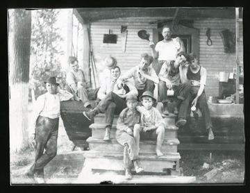 Several boys and men are sitting on a porch in Parkersburg, West Virginia.
