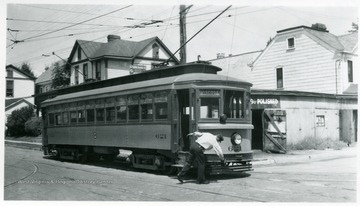 'Monongahela - West Penna P. S.' Driver is fixing something on the front of the trolley.