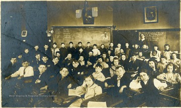 Group portrait of a third grade class with teacher inside a classroom, Sistersville, W. Va.