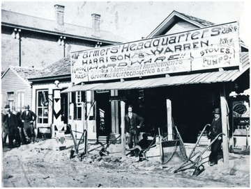 Men stand by equipment outside of the hardware store.