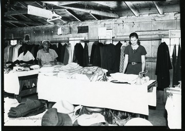 Two African-American women and another woman are looking at sale items at Scotts Run Reciprocal Economy Salvage Sale in Morgantown, West Virginia.