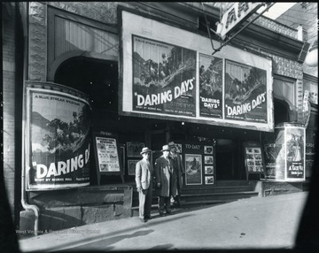 Three unidentified men stand in front of the theatre.