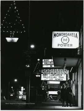 A couple standing outside the Metropolitan Theatre on High Street, Morgantown, W. Va.