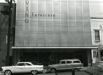 Cars parked in front of the Loving Furniture building.