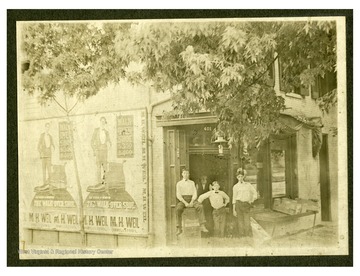 Four men are standing in front of Dawson's News Stand in Morgantown, West Virginia. There are: (right) Grover 'Coopeye' Rice, H. Ott Garrison 'Hog' (middle), ? Fox 'Foxy' (left) and Fenton Rice (rear) High and Fayette Streets. Centennial edition of Morgantown Post.