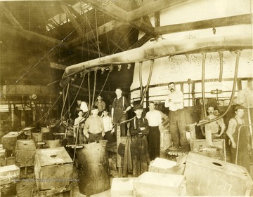 Glassworkers from local glass company in Morgantown, W. Va. Workers surrounded by materials and equipment. 