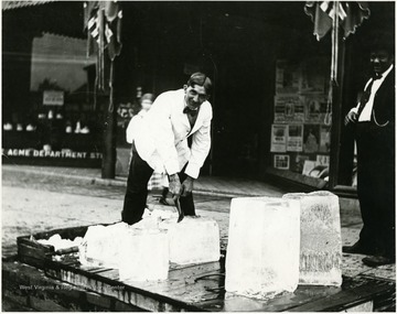 Harry Selby is cutting ice in front of the Acme Department Store on the Corner of High and Fayette Streets.