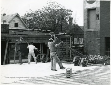 Four men working on the construction of Massulo's Dry Cleaners on High Street, Morgantown, W. Va.