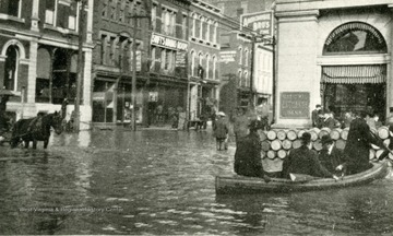 Main Street from 12th Street, Flood of March 1907 at Wheeling W. Va. People and horses seen wading through water, also some people are in boats. 