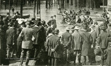 Crowd at end of Steel Bridge, flood of March 1907 in Wheeling, W. Va. People can be seen in boats. 