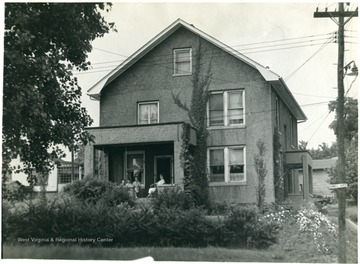 A few people sit on the porch of the Molby home on Cornell Avenue.