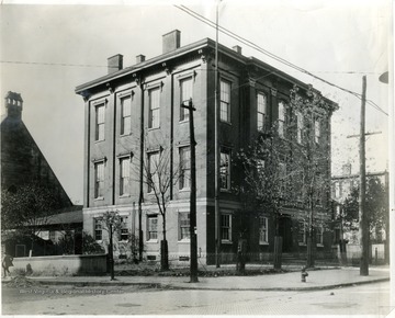 A man walking past the Linsly Institute, the first capitol building in Wheeling, West Virginia.