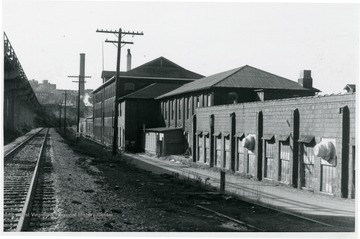 'View of East side of building along RR looking south.  Additions in the foreground and both portions of original woolen mill.'