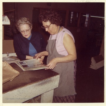 Both ladies are looking at a photo album.