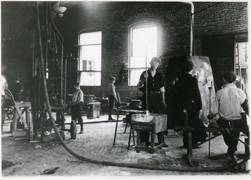 Men and boys work inside the glass factory. Credit, National Archives, Washington, D.C.; 102-LH-169.