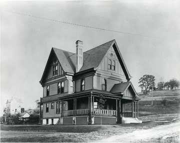 This house was built by W.E. Rumsey located at 443 Park Street. Another house can be seen behind this structure. Park Street is unpaved.