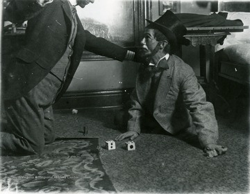 Two men seen here during a scene of a play. Seem to be in a fight over a game. 