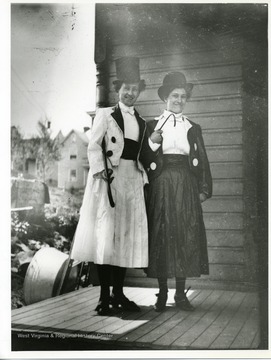Two costumed women are standing on a porch in Morgantown, West Virginia.