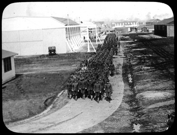 World War I Lantern Slide Show. Slide No. 15 in group of originally numbered slides. Student pilots marching on grounds of military base.  Frame is labelled with text saying 'Visual Bureau, University of Pittsburgh.'  (negative no. 15-5965 is inscribed on slide)<br />