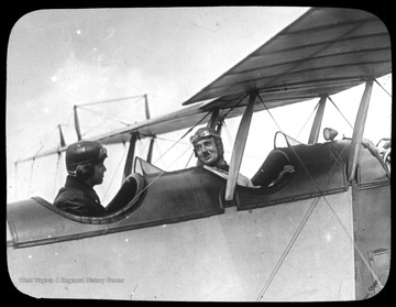 World War I Lantern Slide Show. Slide No. 20 in group of originally numbered slides. Pilot in cockpit of biplane facing observer.  Frame is labelled with text saying 'Visual Bureau, University of Pittsburgh.'  (negative no. 21-10034 is inscribed on slide)<br />