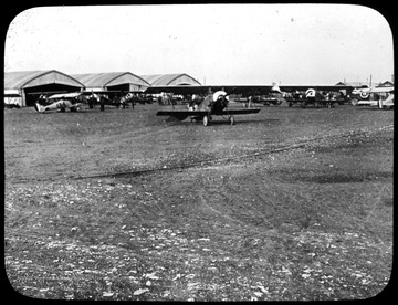 World War I Lantern Slide Show. In group of originally numbered slides.  (Number label is lost.)  Royal Flying Corps airfield, including several hangers and airplanes.  Frame is labelled with text saying 'Visual Bureau, University of Pittsburgh.'  (negative no. 16-10304 is inscribed on slide)<br /><br /><br />