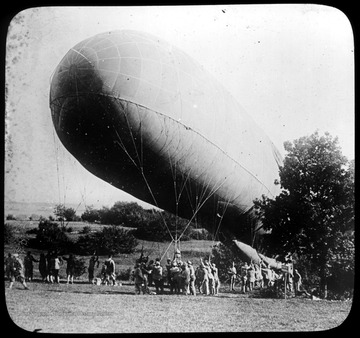 World War I Lantern Slide Show. In group of originally numbered slides.  (Number label is lost.)  Observation balloon near ground being hoisted by cables by soldiers.  Frame is labelled with text saying 'Visual Bureau, University of Pittsburgh.'<br />