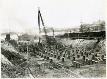 'Photograph No. 103; View showing steel H piles being driven and bearing plates placed for coke oven foundation.  Looking south. January 30, 1941, 12:30 P.M.'