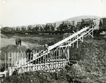 Sand trucks on Railroad cars. Men building a wooden framework. 