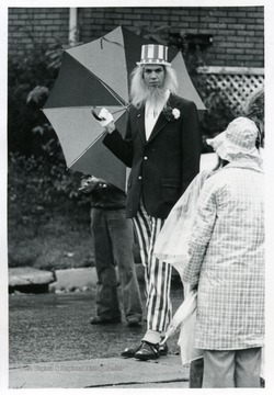 Man dressed as Uncle Sam holding a umbrella.