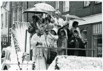 Group of women on a truck in period clothing.