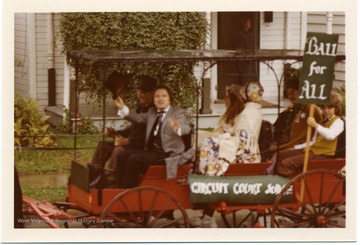 A horse drawn wagon in pulling people advertising Ball for Circuit Court Judge during the Monongalia County Bicentennial Parade in Morgantown, West Virginia.