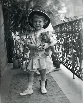 A little girl holds onto her teddy bear in this picture. 