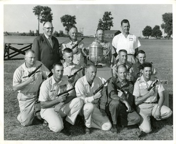'U.S. International Pistol Team gathered around Mayleigh Challenge Cup. Kneeling from left: CPO D. McCoy, SSgt. Tommy Krumar, Capt. Allyn Clark, John W. Hurst, Stephen G. Webber, SFC Robert E. Monts, SSgt. Larry L. Hausman, MSgt. Roy Ratliff. Standing from left, Charles E. Boomhower, team captain, MSgt. Johnnie M. Martin, SSgt. Albert R. Froede and Dr. Guy C. Davis, team adjutant.' If you want to publish this photograph, please contact the U.S. Army for permission.