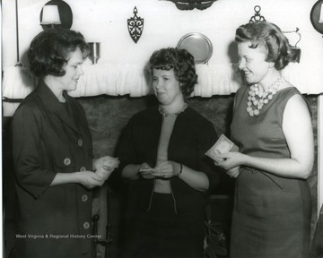 Three members of the Service League in Morgantown, West Virginia. Left to right: Mrs. Jake Murphy, Mrs. Arthur Morris, and Mrs. Don J. Eddy, wife of County Judge.