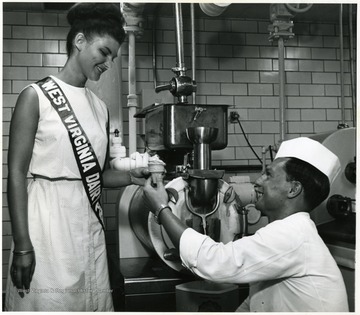 An dairy worker gives Pamela Link, Dairy Princess, an ice cream cone.