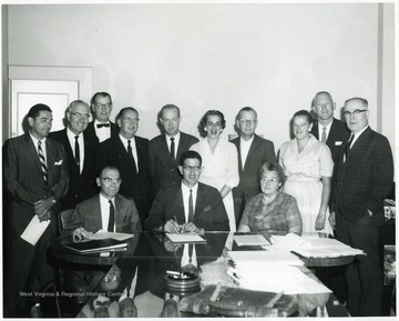 'Top row, left to right: James McCarthy, Pres. Chamber of Commerce, Lawrence Snyder, Glenn Zinn, J. W. Ruby, Pres. Sterling Faucet, unknown, Mrs. Joe Stenger, Mr. Joe Stenger, unknown, unknown, George Farma.  Bottom row, left to right: Martin Diribek, John Solomon, unknown.'