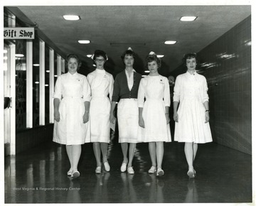 A group of five nurses at the Medical Center pose in front of the Gift Shop.